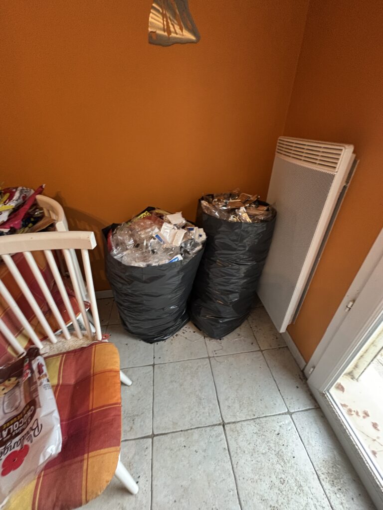 Accumulation de sacs-poubelle dans un logement insalubre à Marseille, avant protocole de nettoyage et d’assainissement.
